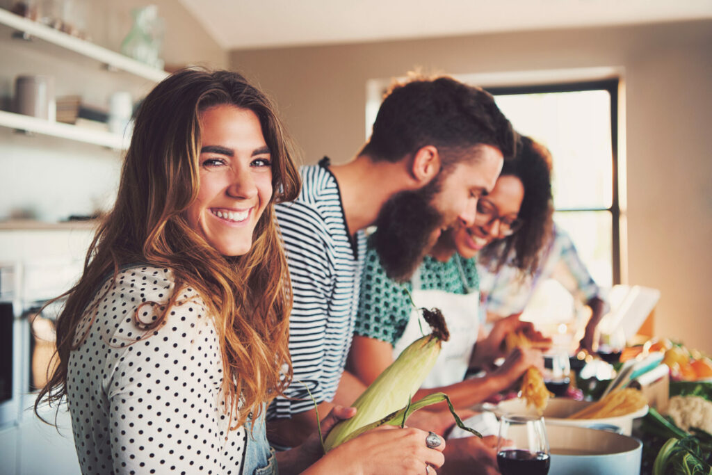 Happy people peeling vegetables in a kitchen